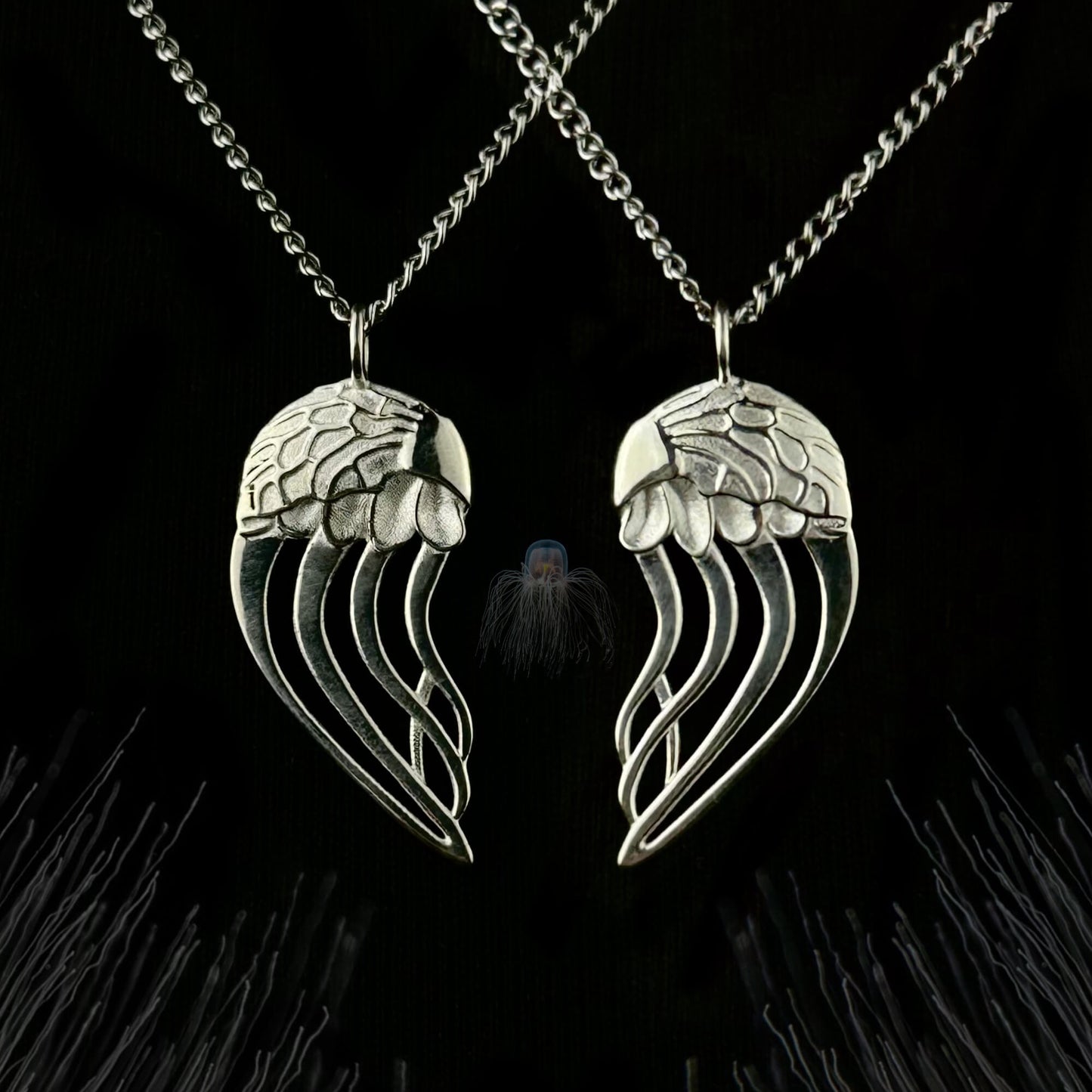 Close-up of the Jellyfish necklace pendants, featuring left and right designs crafted in sterling silver. The two pieces can be worn together to form a heart, symbolizing immortality and eternal love.