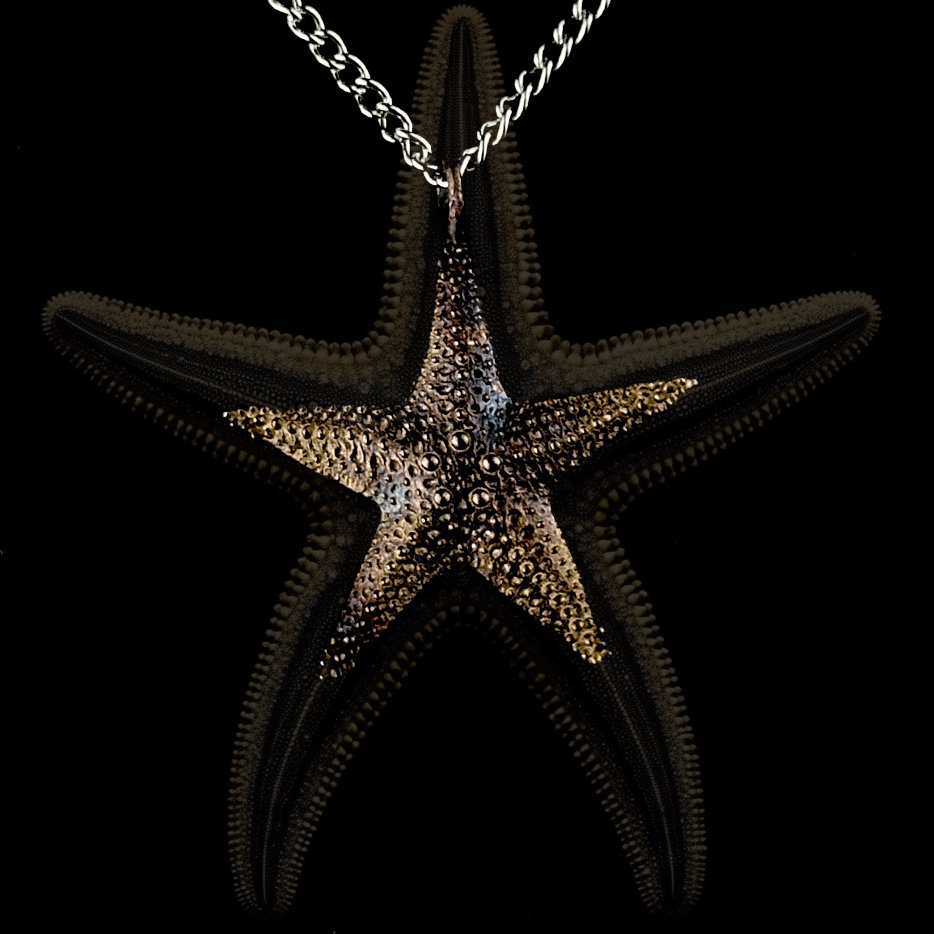 A close-up of the starfish pendant, featuring intricate detailing that mimics the natural texture of a real starfish. The necklace hangs from a silver chain against a black background with a blurred starfish-like pattern.